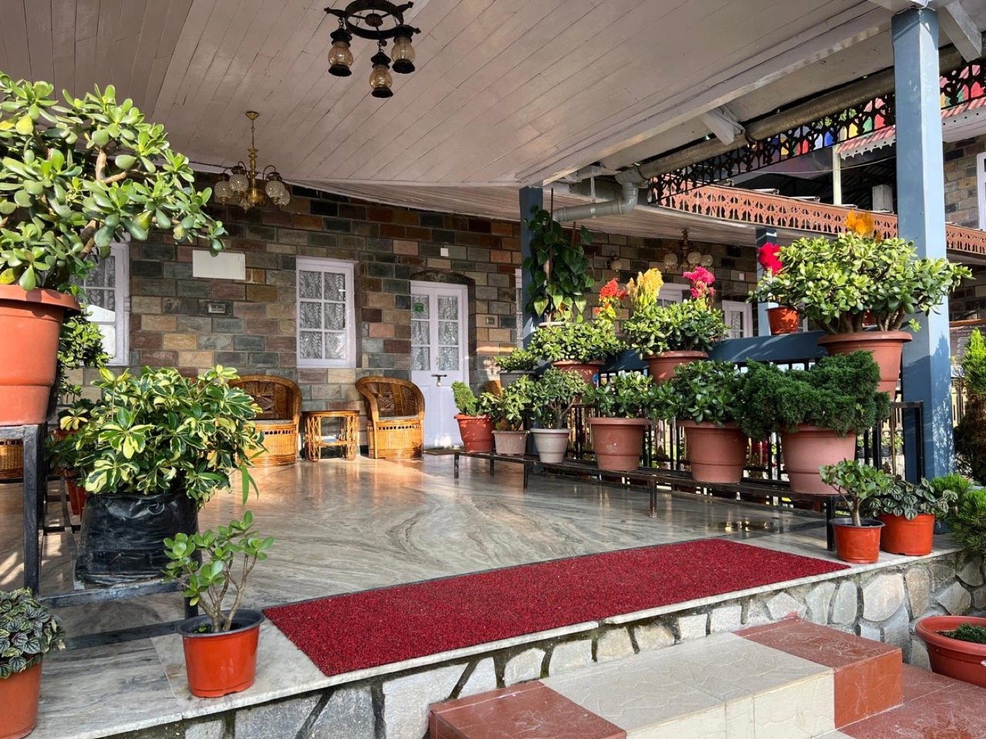 Flower-filled heritage verandah at Saino Heritage Bungalow in Takdah
